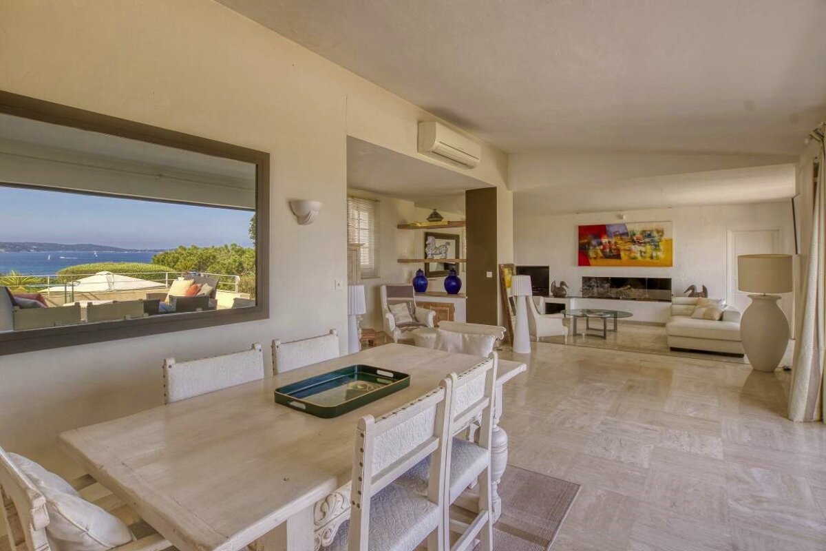 A living room with a table and chairs and a large mirror