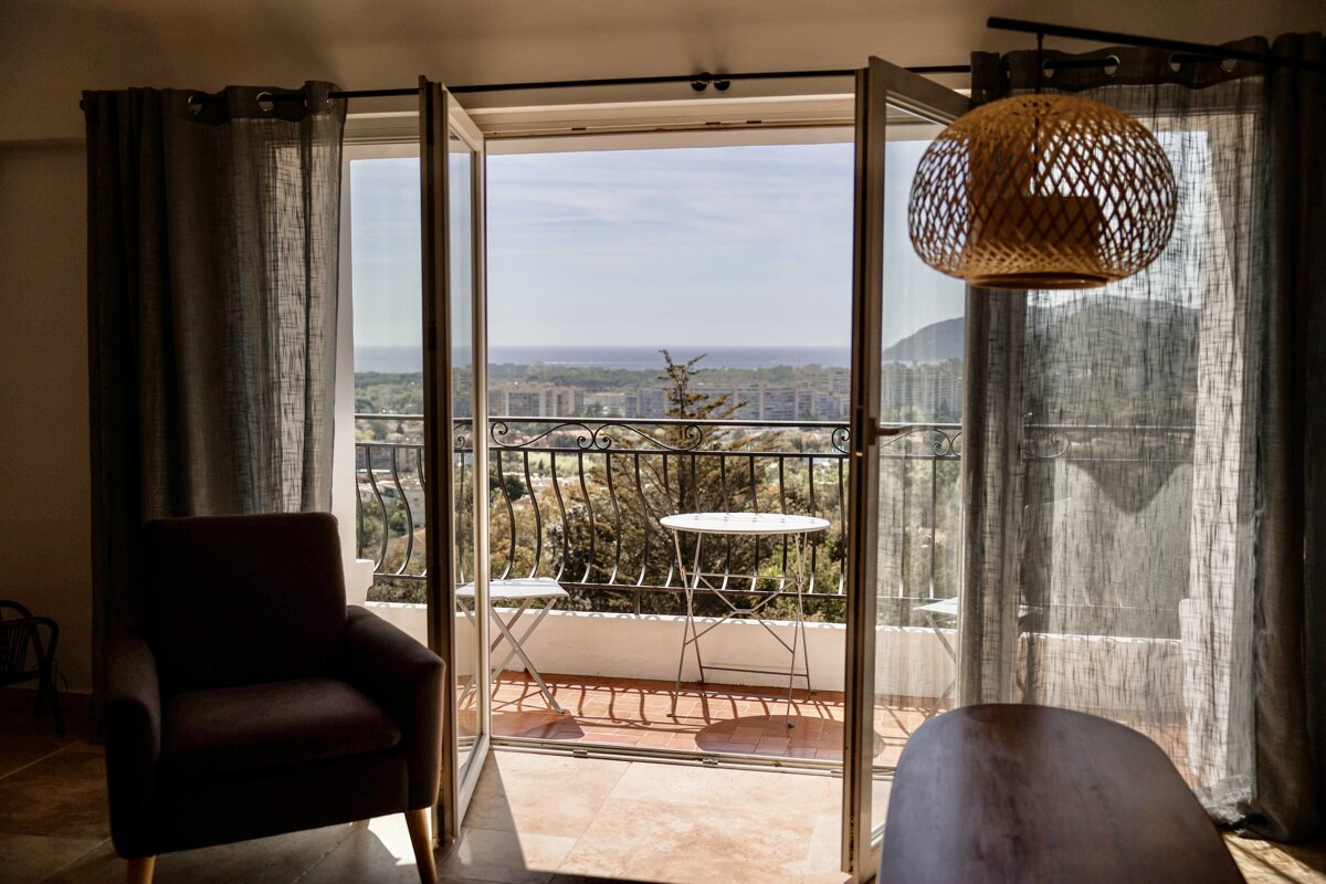 A balcony with a view of the ocean and mountains