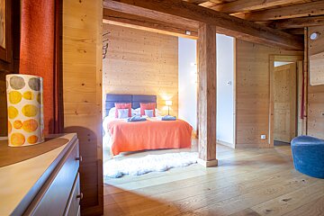 A bedroom with a bed and a lamp with circles on it