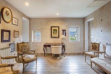 A room with chairs and a desk with a picture of a woman on the wall