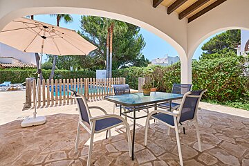 A patio with a table and chairs and an umbrella