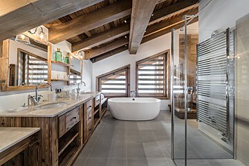 A bathroom with a bathtub and two sinks