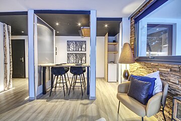 A living room with a table and chairs and a lamp