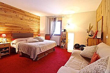 A bedroom with a large bed and a couch