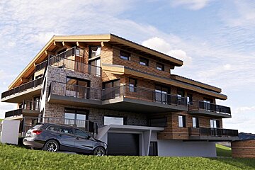 A modern stone and wood chalet with multiple balconies, a garage, and a dark car parked on a green hillside under a cloudy sky.