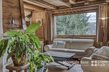 A living room with a couch and a plant and a sign that says mountain base