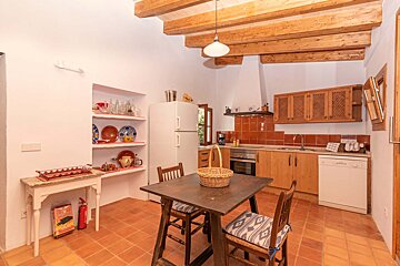 A kitchen with a table and chairs and a fire extinguisher