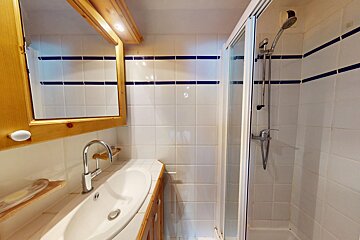 A bathroom with a sink and a walk in shower