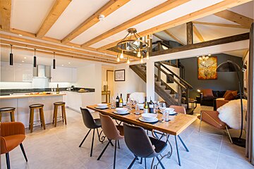 A dining room table with plates and wine bottles on it