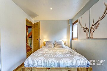 A bedroom with a bed and a painting of a deer by knight frank