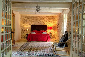 A bedroom with a rocking chair and a rug