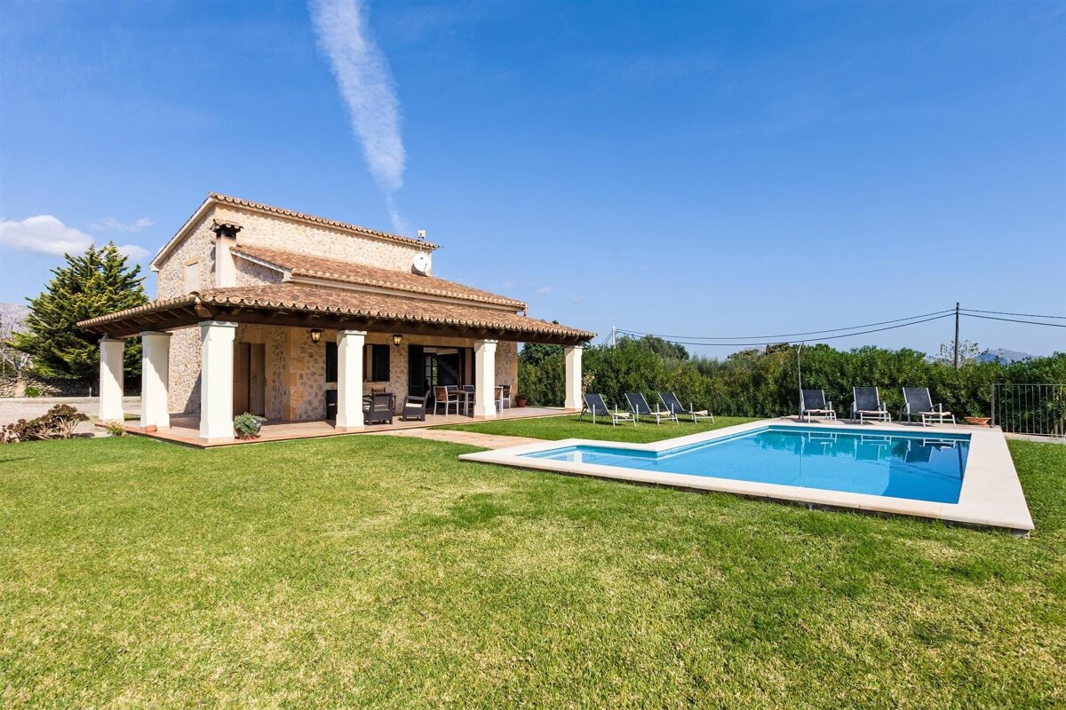 A house with a large swimming pool in front of it