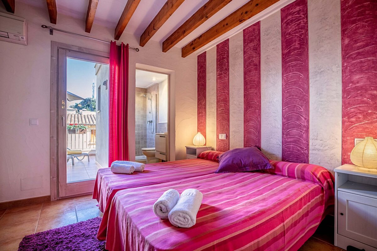 A bedroom with pink and white stripes on the wall