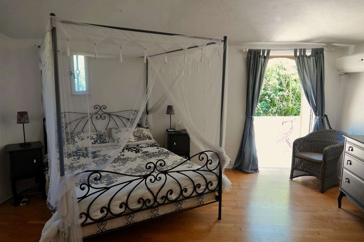 A bedroom with a canopy bed and a chair
