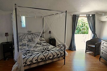 A bedroom with a canopy bed and a chair