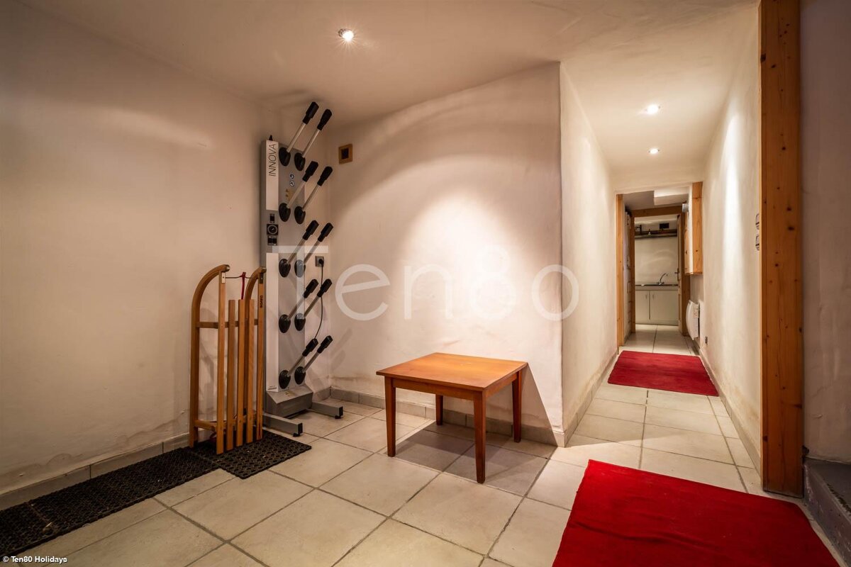 A hallway with a boot dryer and a small table