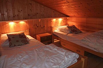 A bedroom with two beds and a nightstand