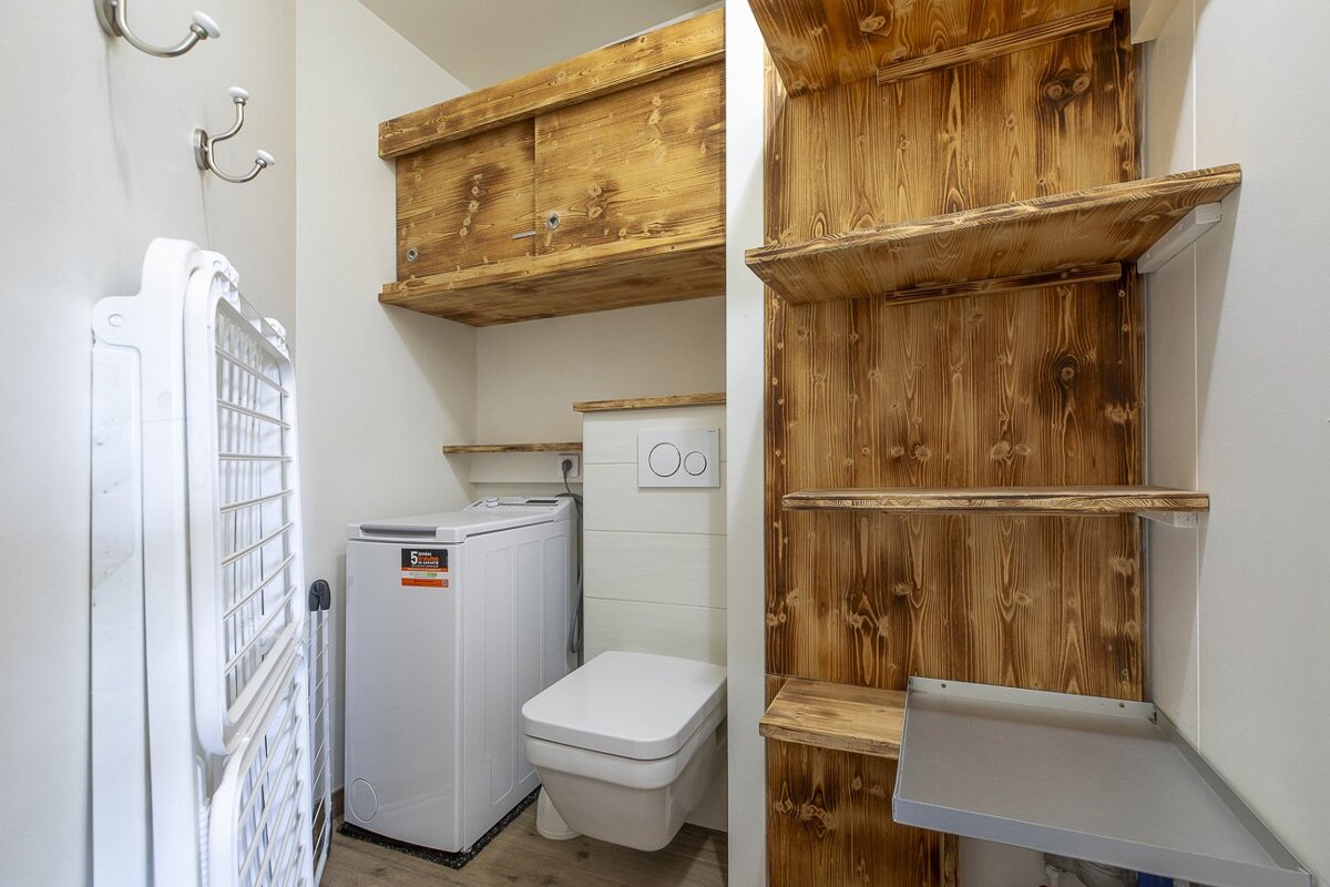 A bathroom with a washer and dryer and a toilet