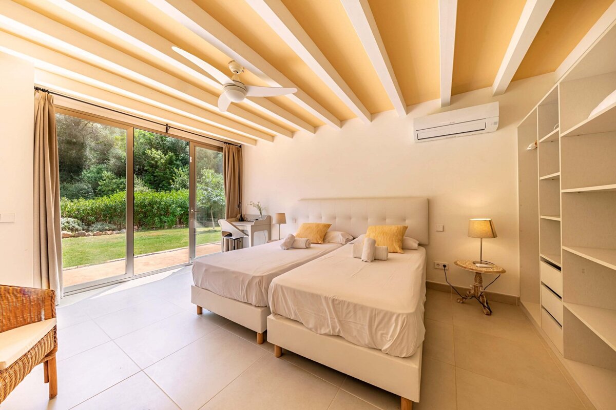 A bedroom with two beds and a ceiling fan