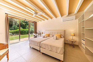 A bedroom with two beds and a ceiling fan