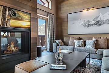 A living room with a couch and a fireplace and a bottle of moet