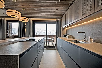 A kitchen with a sliding glass door leading to a balcony
