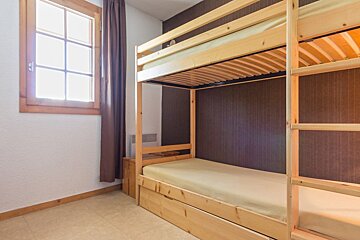 A bedroom with bunk beds and a window