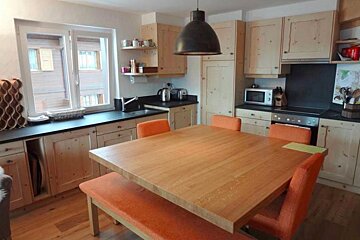 A kitchen with wooden cabinets and orange chairs