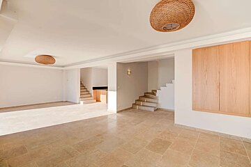 An empty room with a wicker lamp hanging from the ceiling