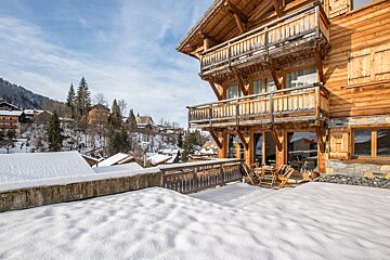 A large wooden building with a balcony in the snow