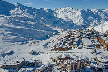 An aerial view of a ski resort with mountains in the background