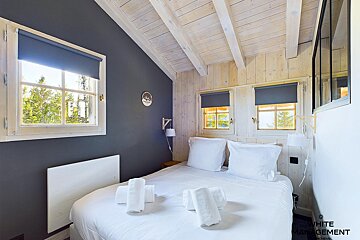 A white management photo of a bedroom with a bed