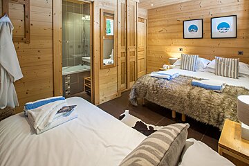 A bedroom with two beds and a bathroom