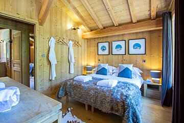 A bedroom with a bed and three pictures on the wall