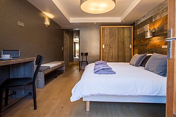 A hotel room with a bed and a desk