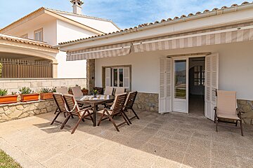 A patio with a table and chairs under an awning