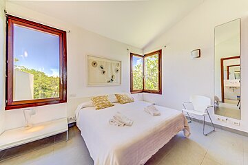 A bedroom with a large bed and a large mirror