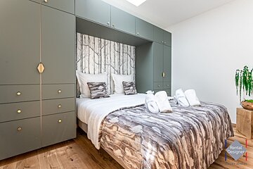 A bedroom with a bed and a sign that says rental designer