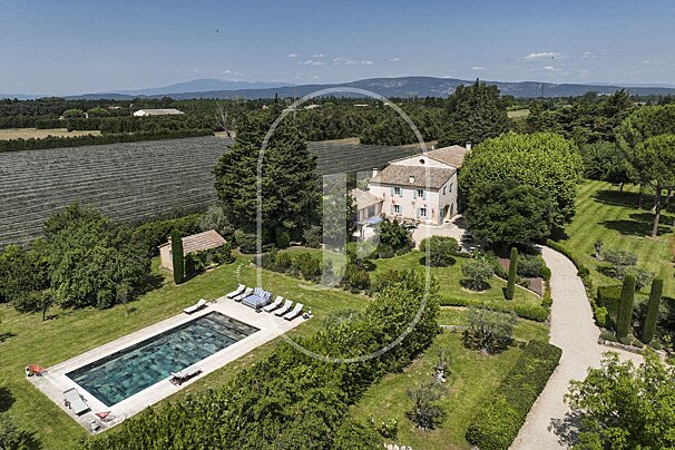 An aerial view of a house with a large swimming pool