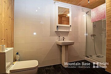 A bathroom with a toilet and a sink and a sign that says mountain base