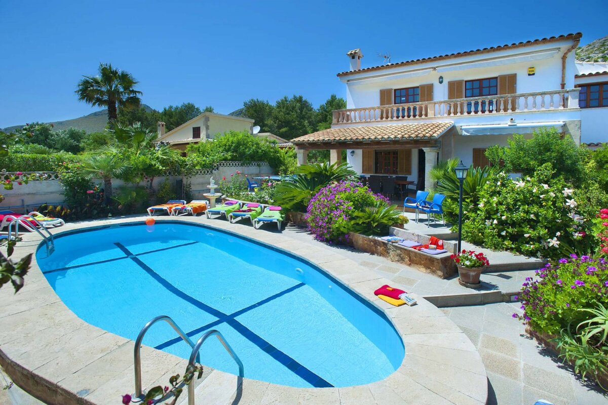 A house with a large swimming pool in front of it