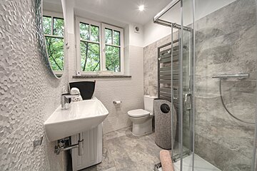 A bathroom with a toilet a sink and a window