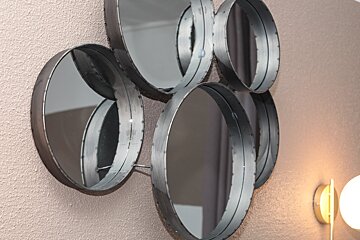 A group of round mirrors hanging on a wall