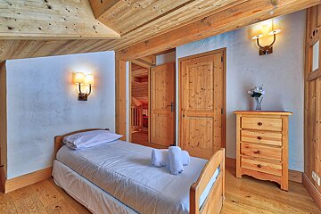 A bedroom with a single bed and a dresser