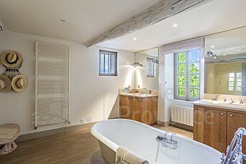 A bathroom with a bathtub and two sinks with the word provence on the wall