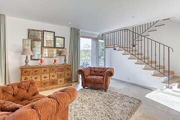 A living room with two chairs and a staircase