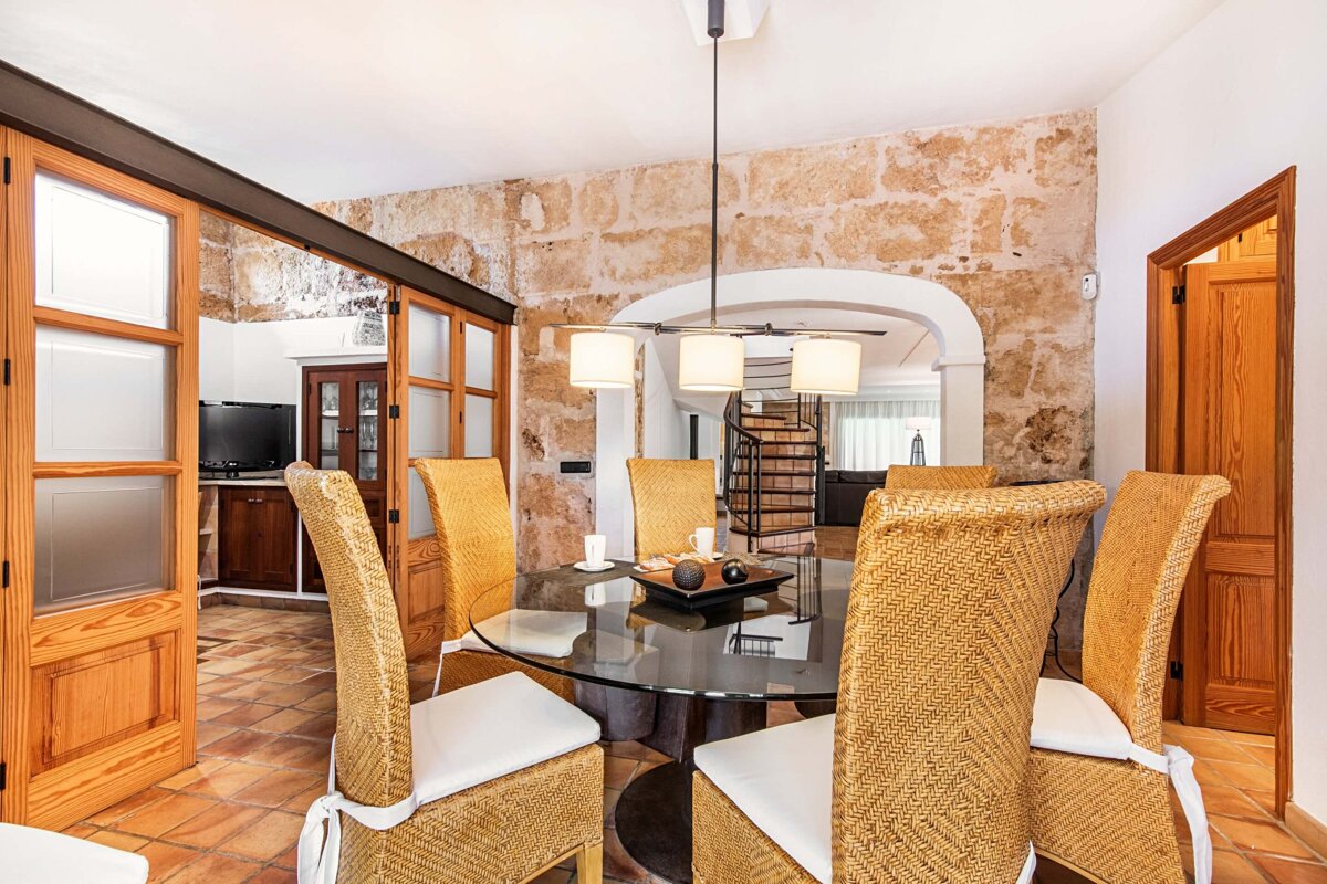 A dining room with wicker chairs and a glass table