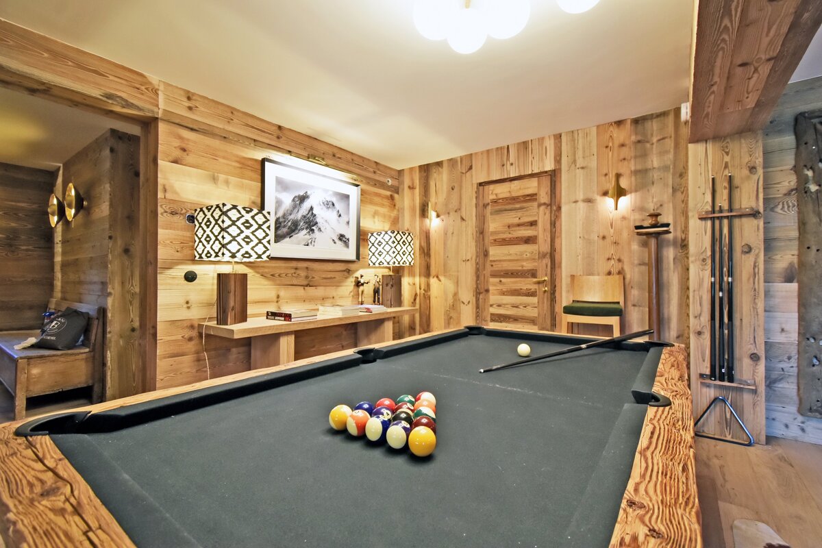 A pool table in a room with wooden walls