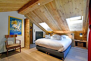 A bedroom with a bed and a chair and a poster on the wall that says ' l' alpe ' on it