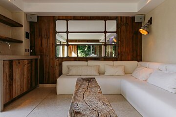 A living room with a white couch and a wooden table